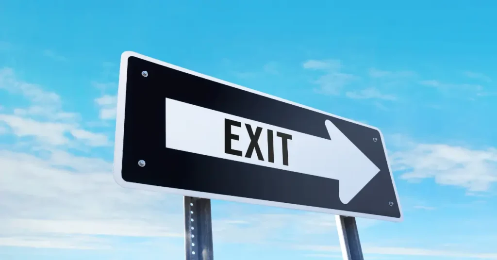 Exit sign with an arrow pointing right, symbolising wealthy individuals leaving the UK.