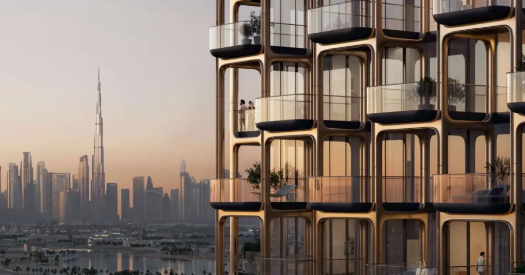 Close-up view of The Symphony by Imtiaz’s sculpted façade designed by Zaha Hadid Architects, featuring curved glass balconies overlooking the Dubai skyline and Burj Khalifa at sunset.