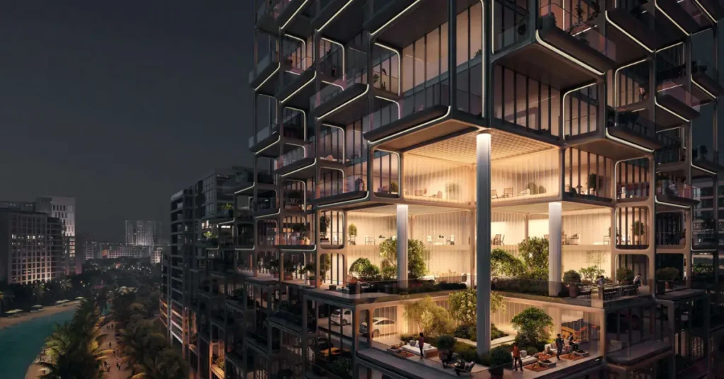 Night view of The Symphony’s illuminated sculptural façade, highlighting multi-level terraces, landscaped podium gardens, and warm ambient lighting.