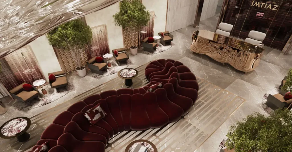 Grand residential lobby of The Symphony featuring a sculptural burgundy sofa, marble flooring, artistic décor, and warm ambient lighting.