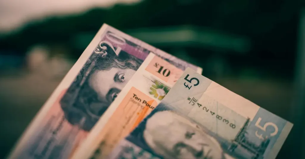Close-up of £5 and £10 British pound notes symbolising UK wealth and taxation.