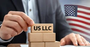 Business owner stacking blocks labelled US LLC symbolising company formation and legal protection for non-US entrepreneurs.