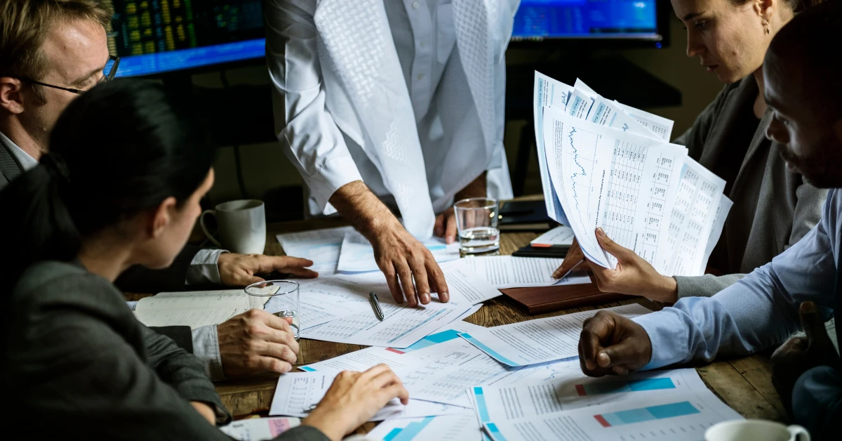 Business team reviewing bank account application documents and financial paperwork for a Dubai company